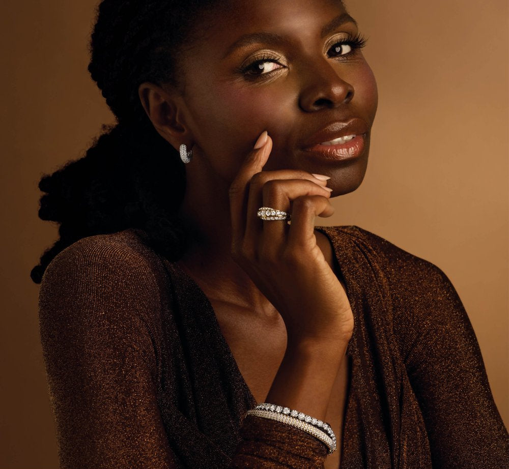 Woman wearing a diamond ring against a brown background