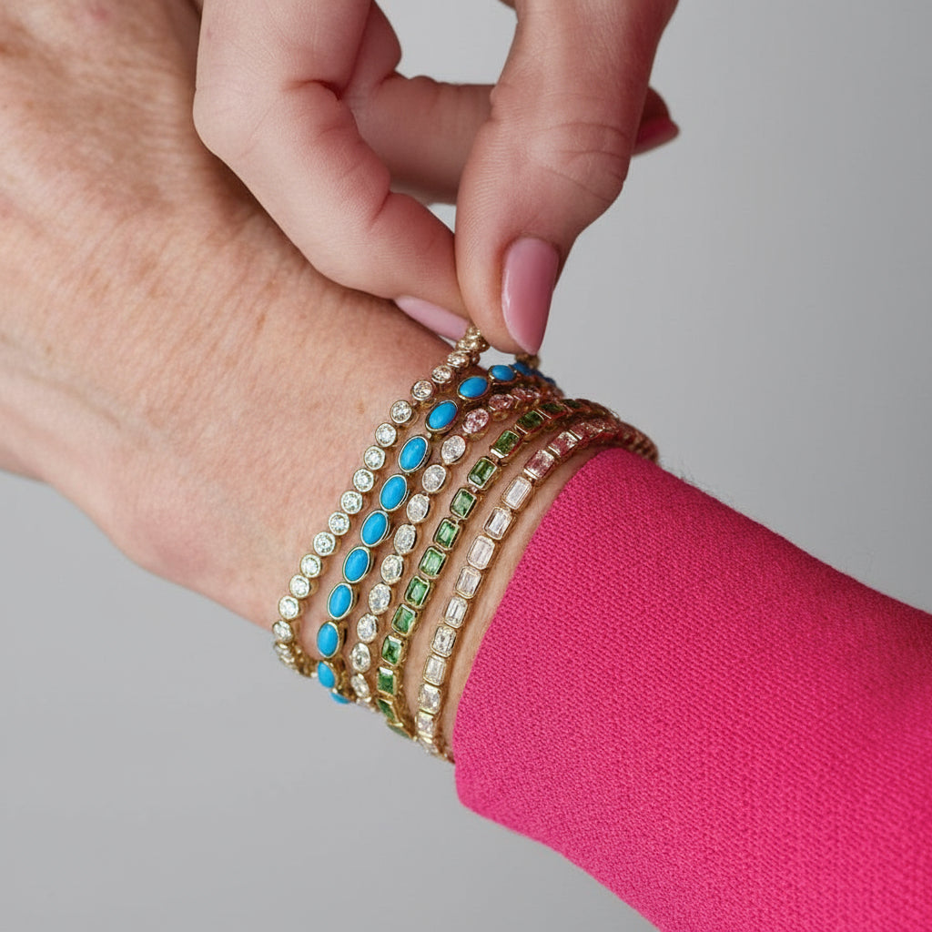 Close-up of a hand wearing a colorful bracelet on a pink background