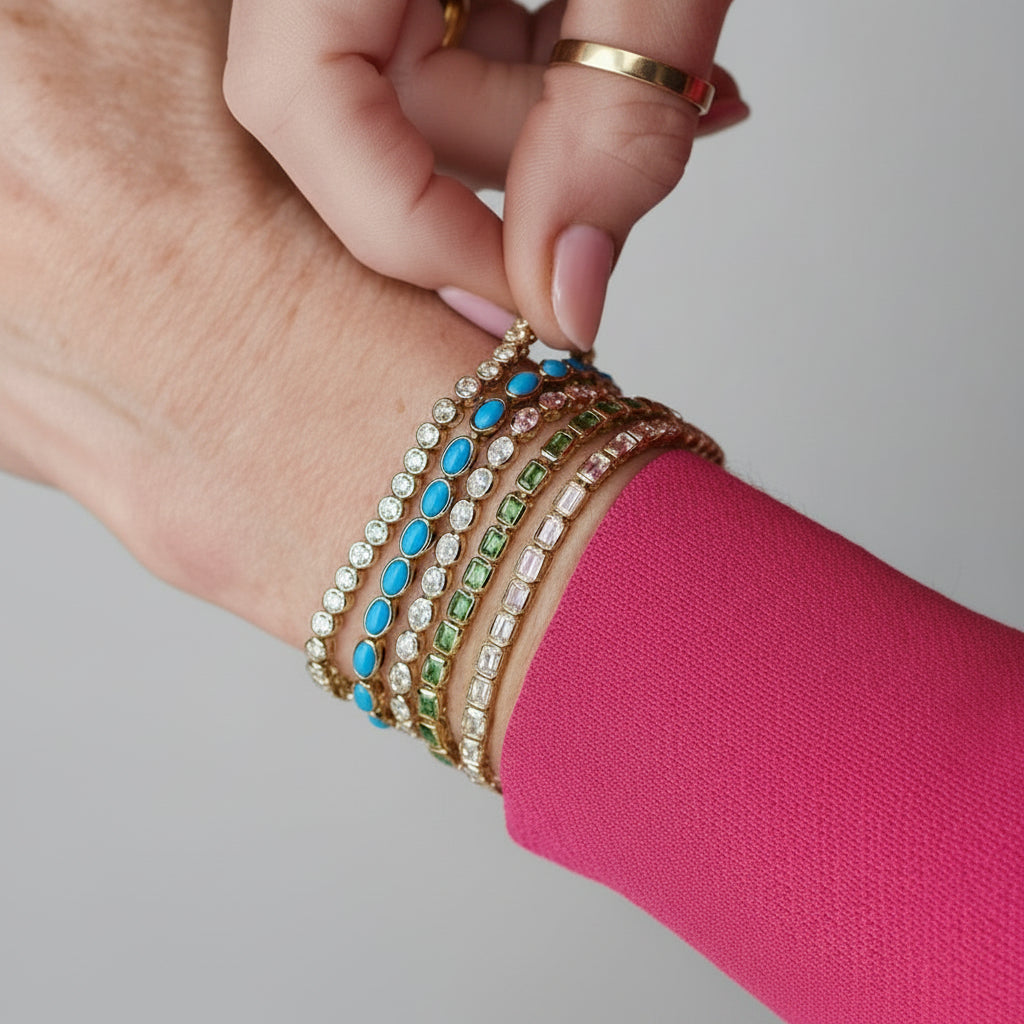 Close-up of a hand wearing a colorful bracelet on a pink background