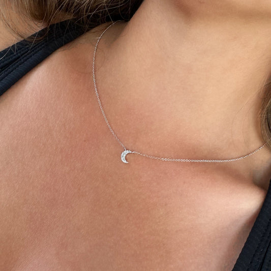 model wearing a white gold necklace with a crescent moon pendant