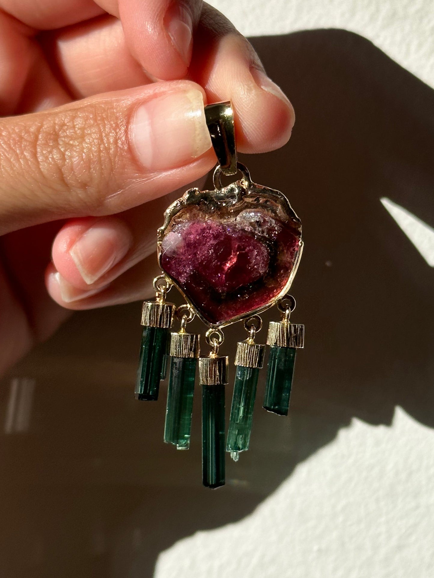 watermelon tourmaline pendant being held by hand