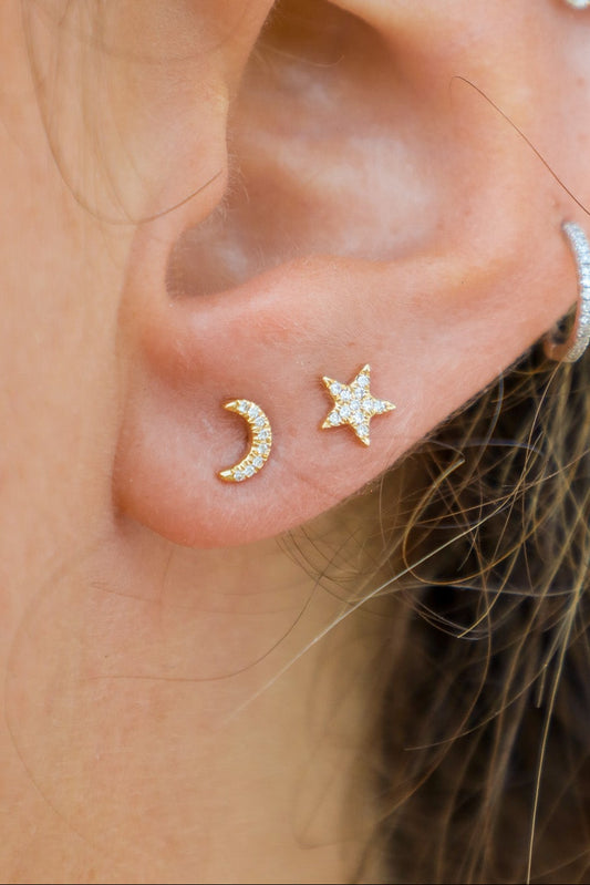 Close-up of an ear with gold earrings and a blurred background