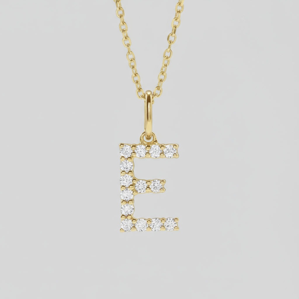 A gold lab grown diamond initial necklace with a personalized touch, displayed on a white marble surface.