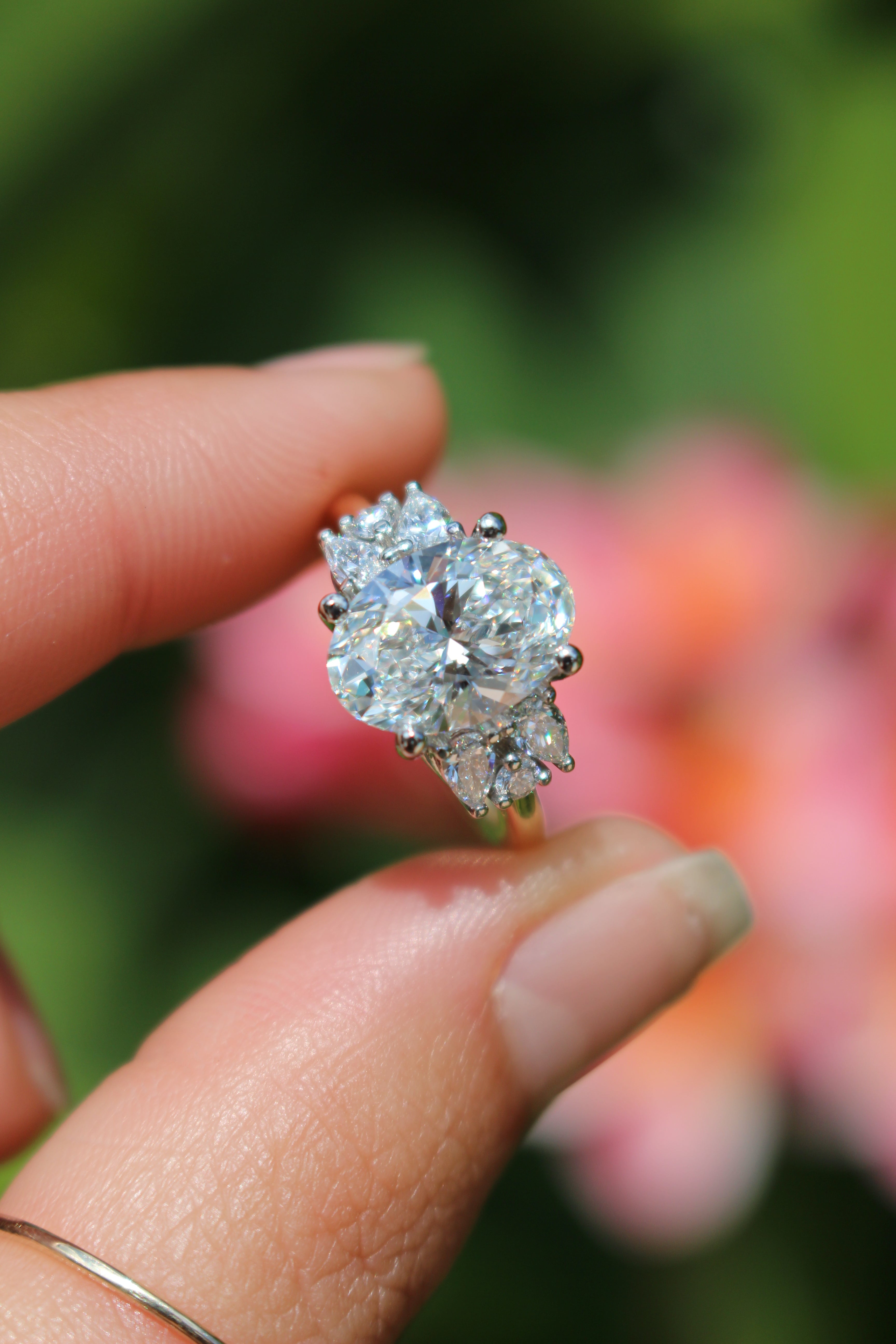 Diamond ring held by a hand with a blurred background