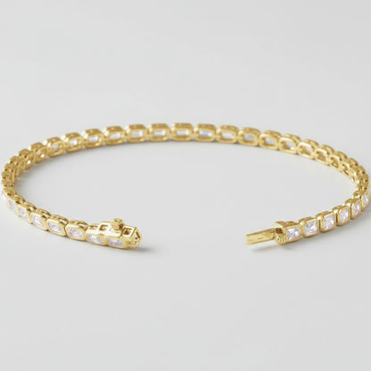 Gold Lab Grown Emerald Tennis Bracelet with clear diamonds on a white background