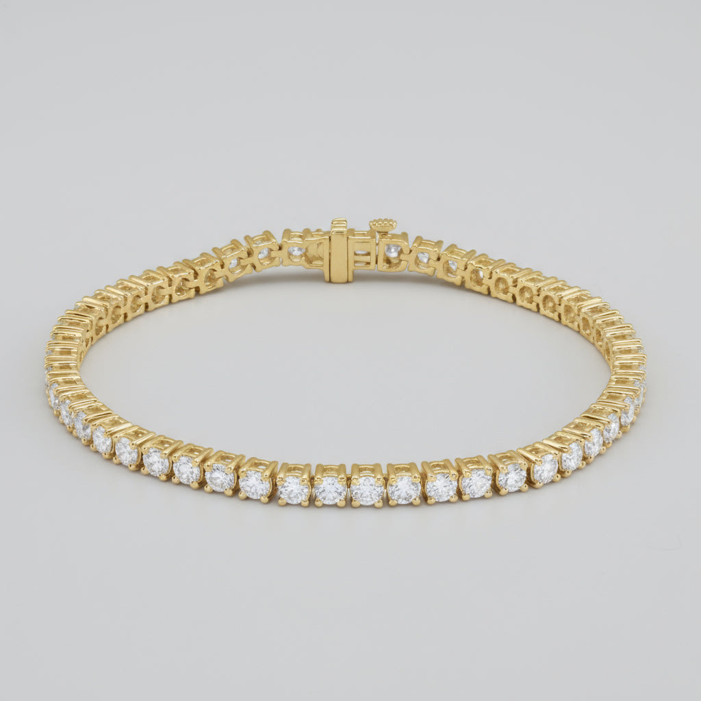 Gold bracelet with clear gemstones on a white background