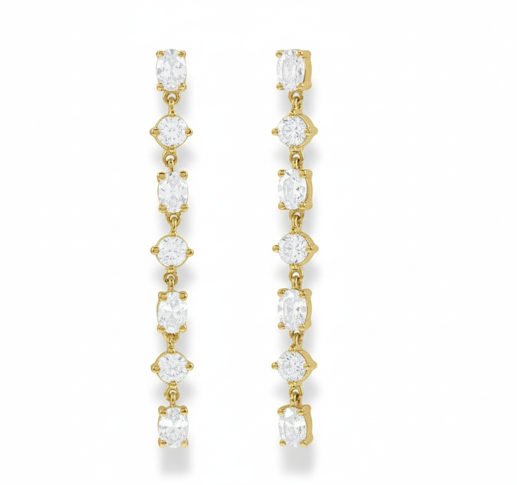Gold earrings with clear gemstones on a white background