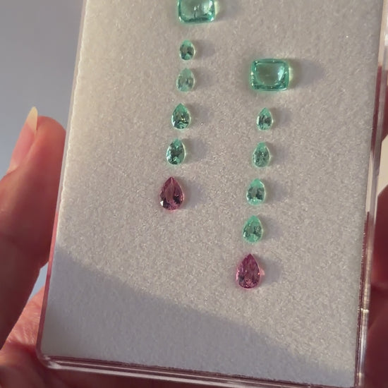 A layout of Paraíba Tourmaline gemstones in a pattern for a custom earring design