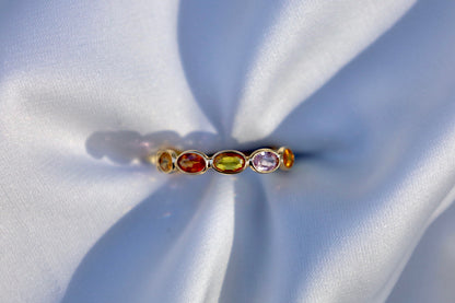 Ring set with oval shaped multi-colored sapphires bezel set in gold.